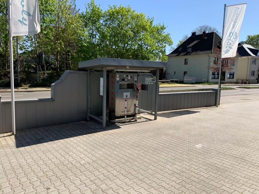 Eine Autogas-Tankstelle auf einem gepflasterten Platz bei sonnigem Wetter.